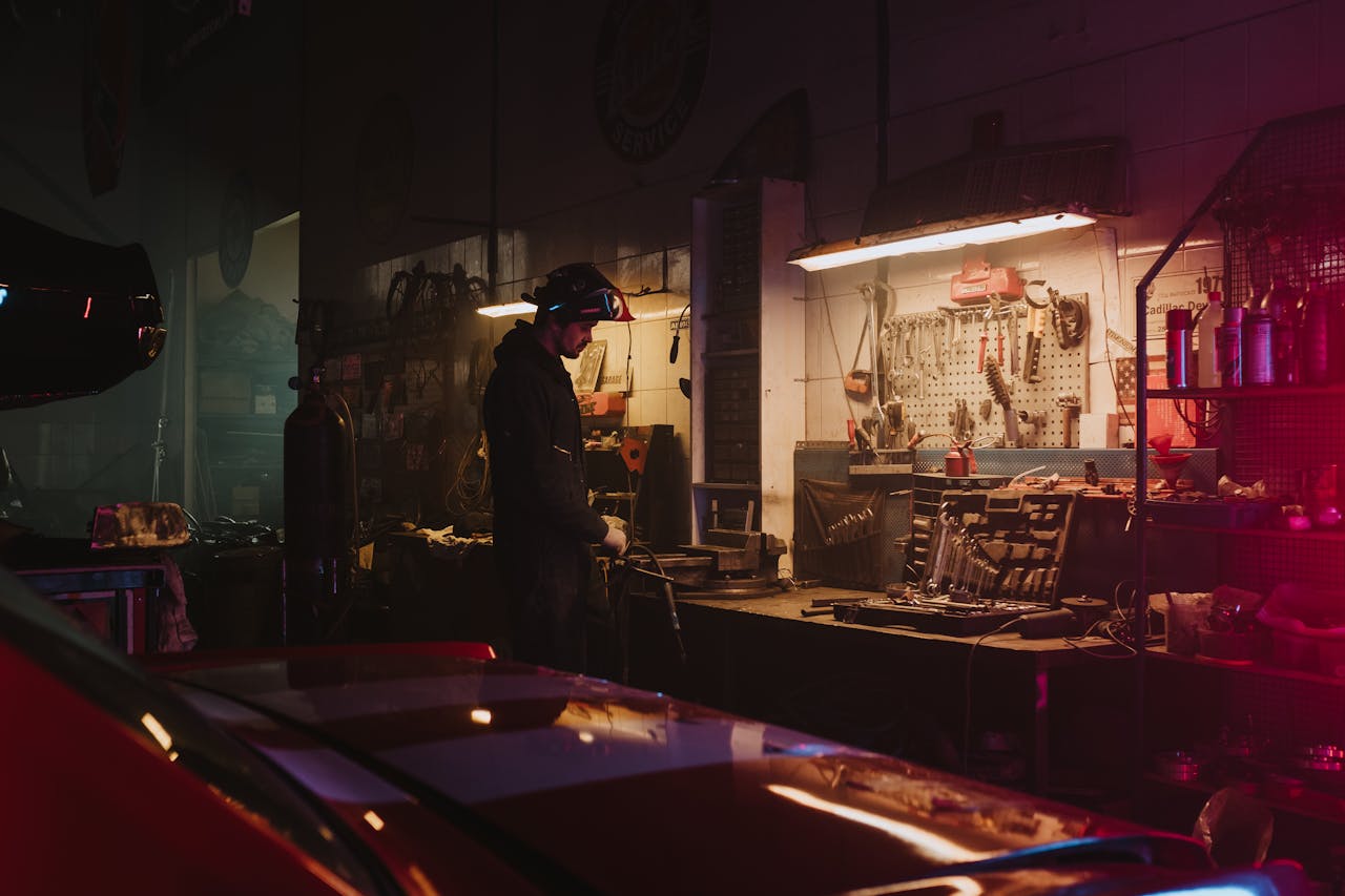 Mastering the First Impression: Your intriguing post title goes here Mechanic working in a dimly lit garage workshop surrounded by tools and equipment.